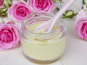 Glas mit einer Flüssigkeit und außen herum Rosen